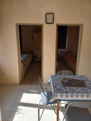 a room with a table and chairs and a clock at Fülöpsziget vendégház in Bogács