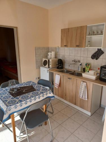 a small kitchen with a table and a sink at Fülöpsziget vendégház in Bogács