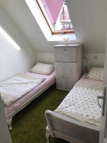 sypialnia na poddaszu z 2 łóżkami i komodą w obiekcie Dom pod barankiem w mieście Mielno