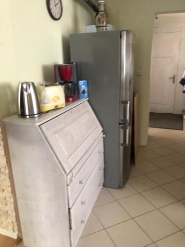 a kitchen with a stainless steel refrigerator and cabinets at Dom pod barankiem in Mielno