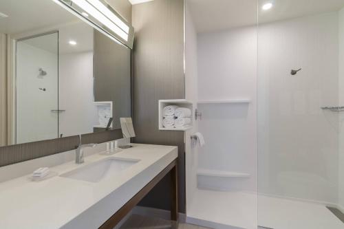 a white bathroom with a sink and a shower at Courtyard by Marriott South Bend Downtown in South Bend