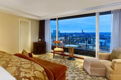 um quarto de hotel com uma cama e uma grande janela em The Park Tower Knightsbridge, a Luxury Collection Hotel, London em Londres