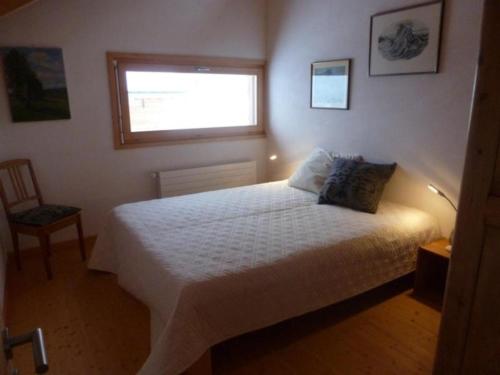 a bedroom with a white bed and a window at Modernes Chalet - Blue Merle in Vercorin