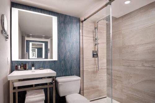 a bathroom with a toilet and a sink and a shower at Vancouver Airport Marriott Hotel in Richmond