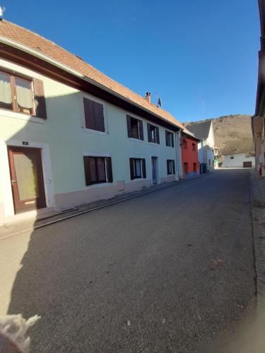 Une rue vide à côté d'un bâtiment blanc dans l'établissement Charmant petit appartement avec bel exterieur., à Saint-Amarin