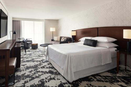リッチモンドにあるSheraton Vancouver Airport Hotelの大きなベッドとリビングルームが備わるホテルルームです。