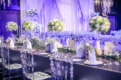 a table set up for a wedding with purple flowers at JW Marriott Hotel Bangkok in Bangkok