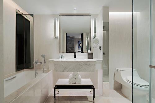 a white bathroom with a sink and a toilet at JW Marriott Hotel Bangkok in Bangkok