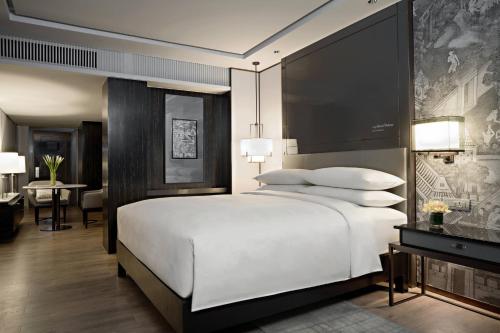 a bedroom with a large white bed and a desk at JW Marriott Hotel Bangkok in Bangkok