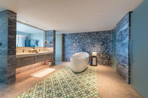 bagno con vasca, lavandino e specchio di W Residences Algarve ad Albufeira