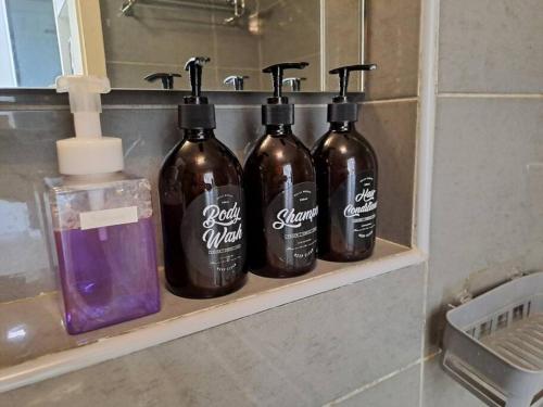 a group of three bottles sitting on a shelf in a bathroom at Best moments in Kuantan