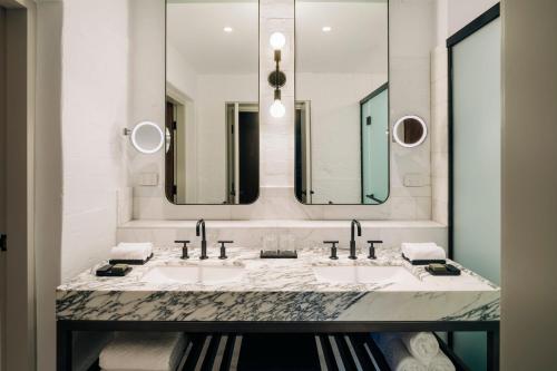 a bathroom with two sinks and two mirrors at The Tasman, a Luxury Collection Hotel, Hobart in Hobart