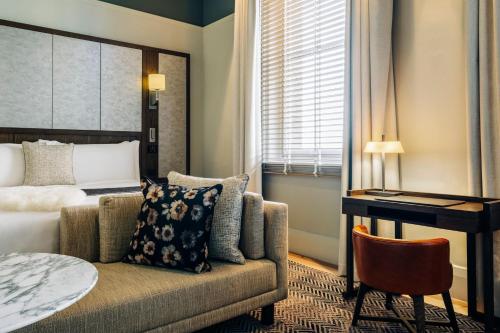 a hotel room with a bed and a couch and a desk at The Tasman, a Luxury Collection Hotel, Hobart in Hobart