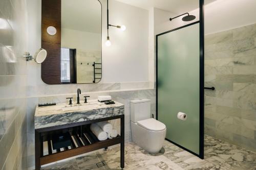 a bathroom with a toilet and a sink and a mirror at The Tasman, a Luxury Collection Hotel, Hobart in Hobart