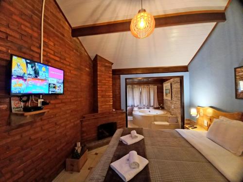 a bedroom with a bed and a tv and a bathroom at Pousada Visconde de Mauá in Visconde De Maua