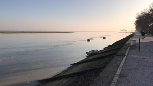 a person walking along the shore of a body of water at Maison Marie Port in Pendé