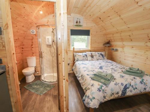 - une chambre avec un lit et une douche dans une cabine dans l'établissement Rowan, à Ulverston