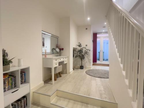 a white hallway with a sink and a mirror at The Snap Pad Boutique Apartment in Royal Tunbridge Wells