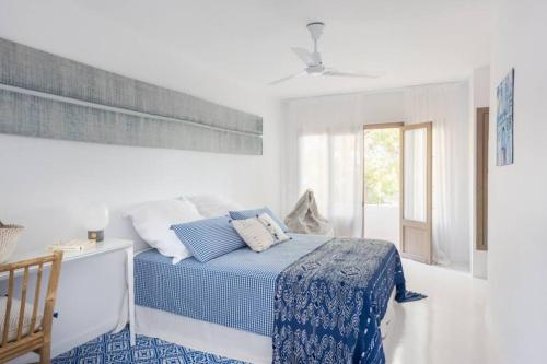 ein weißes Schlafzimmer mit einem blauen Bett und einem Fenster in der Unterkunft Nice house with pool and big porch in Jávea