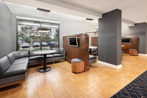 a lobby with a couch and a table and chairs at Courtyard by Marriott Burlington in Burlington