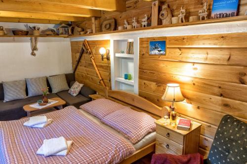 two beds in a room with wooden walls at Chalupa u Žofky in Oščadnica