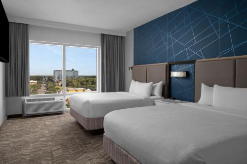 ein Hotelzimmer mit 2 Betten und einem großen Fenster in der Unterkunft SpringHill Suites by Marriott Myrtle Beach Oceanfront in Myrtle Beach