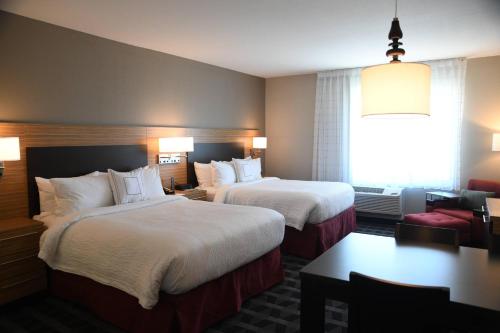 um quarto de hotel com duas camas e uma janela em TownePlace Suites Kansas City At Briarcliff em Kansas City