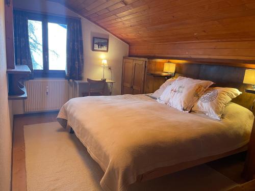 - une chambre avec un grand lit et un plafond en bois dans l'établissement Penthouse - Ski-in Ski-out 30 meters from Medran lift and 40 meters from W Hotel, à Verbier