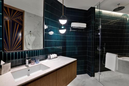 a bathroom with a sink and a shower and a mirror at W Dubai - Mina Seyahi in Dubai