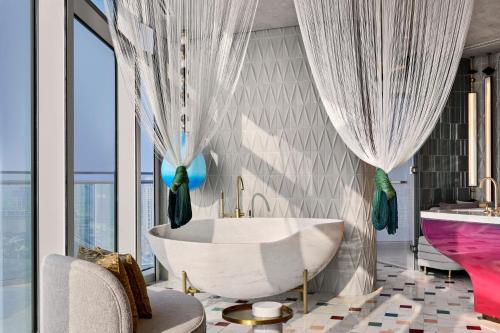 a bathroom with a tub and a large window at W Dubai - Mina Seyahi in Dubai