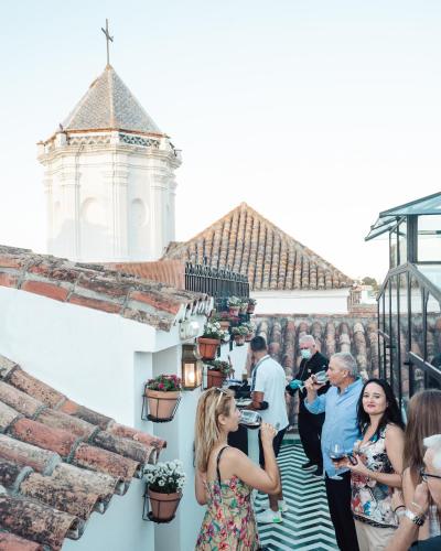 a group of people standing on a balcony drinking wine at Hotel Claude Marbella in Marbella