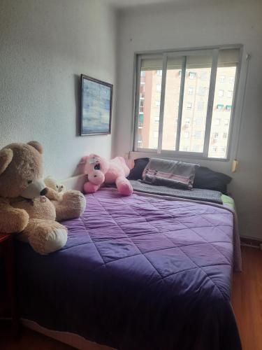 tres animales de peluche sentados en una cama en un dormitorio en Una Habitación Individual en casa familiar dentro de Ciudad Patrimonio de la Humanidad, en Alcalá de Henares