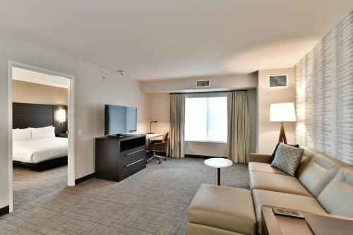 a hotel room with a couch and a bed at Residence Inn by Marriott Eau Claire in Eau Claire