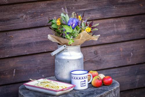 a vase with a bouquet of flowers and apples on a table at Chalupa u Žofky in Oščadnica