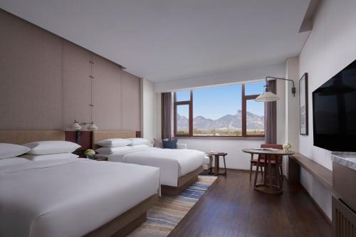 Beijing Marriott Hotel Yanqing في Yanqing: غرفة فندقية بسريرين وتلفزيون بشاشة مسطحة