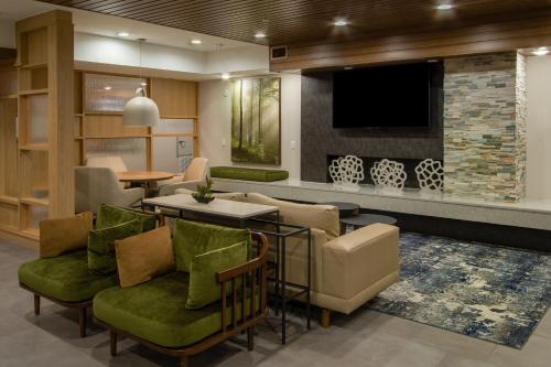 a lobby with a waiting area with a tv and chairs at Fairfield Inn & Suites Houston Katy in Katy