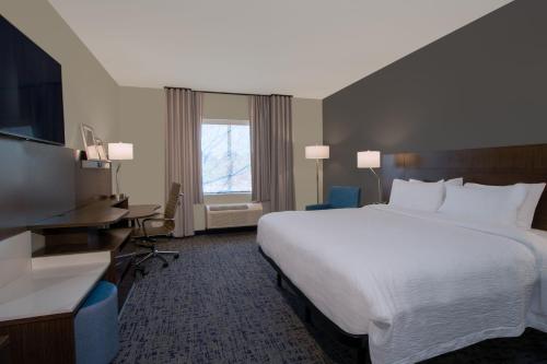 a hotel room with a large bed and a desk at Fairfield Inn & Suites Houston Katy in Katy