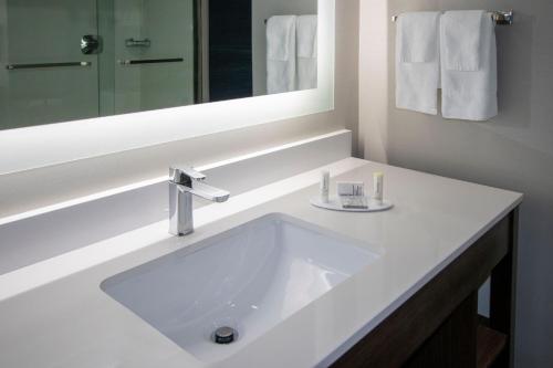 een witte badkamer met een wastafel en een spiegel bij Fairfield Inn & Suites Houston Katy in Katy