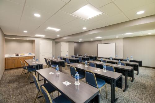 a conference room with tables and chairs and a whiteboard at SpringHill Suites by Marriott Dallas NW Highway at Stemmons / I-35East in Dallas