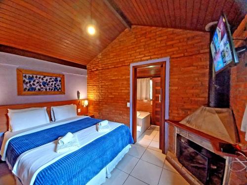 a bedroom with a bed and a tv and a fireplace at Pousada Visconde de Mauá in Visconde De Maua