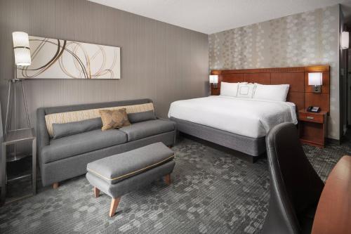 a hotel room with a bed and a couch at Courtyard by Marriott Boulder in Boulder