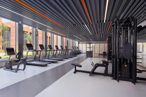 a gym with rows of exercise bikes and treadmills at Tianjin Marriott Hotel National Convention and Exhibition Center in Tianjin