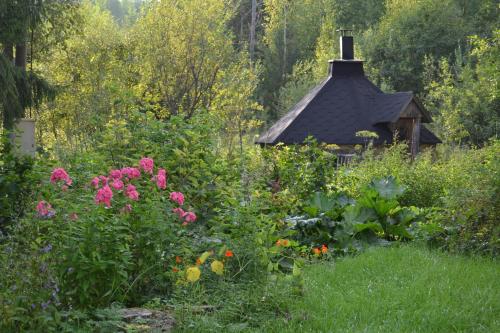 a garden with flowers in front of a gazebo at Pikku Torppa Cottage in Kotka