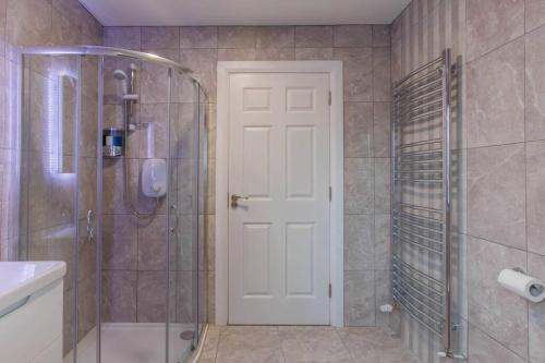 een badkamer met een douche en een witte deur bij St. Edwards Overlook in Sligo