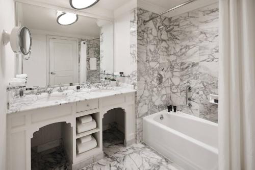 a white bathroom with a tub and a sink and a bath tub at The Ritz-Carlton, San Francisco in San Francisco