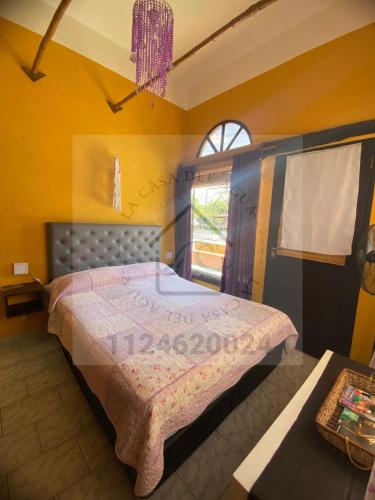 Un dormitorio con una cama con un cartel. en Lacasadelagua en Santa Teresita