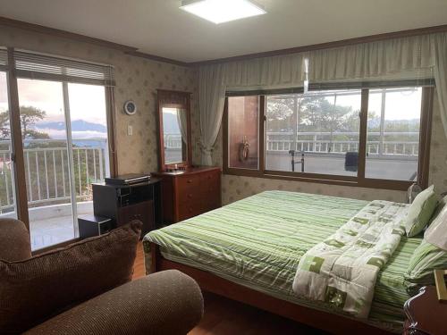 - une chambre avec un lit vert et un balcon dans l'établissement 3 Bedroom Condo Unit With View, à Baguio