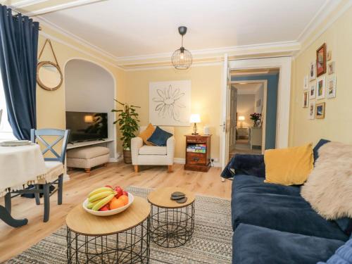una sala de estar con sofá y un bol de fruta en una mesa en 1 Tower House, en Grange-over-Sands
