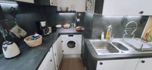 une cuisine avec une machine à laver et un évier dans l'établissement Logette à Ezio, zone piétonne, à Menton