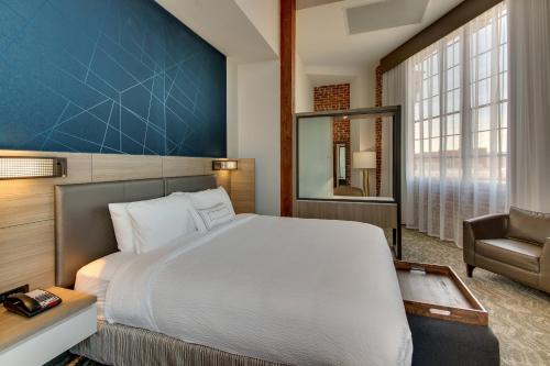SpringHill Suites by Marriott Montgomery Downtown في مونتغومري: غرفة نوم بسرير كبير وكرسي